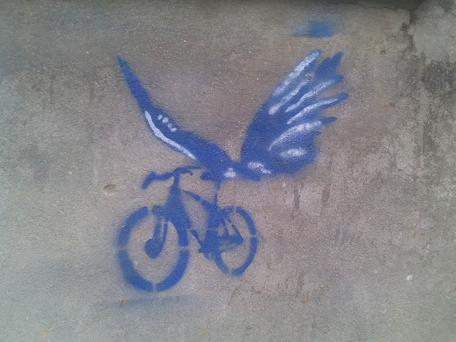 Pochoir d'un vélo avec des ailes de papillon à Kupondole © S.H